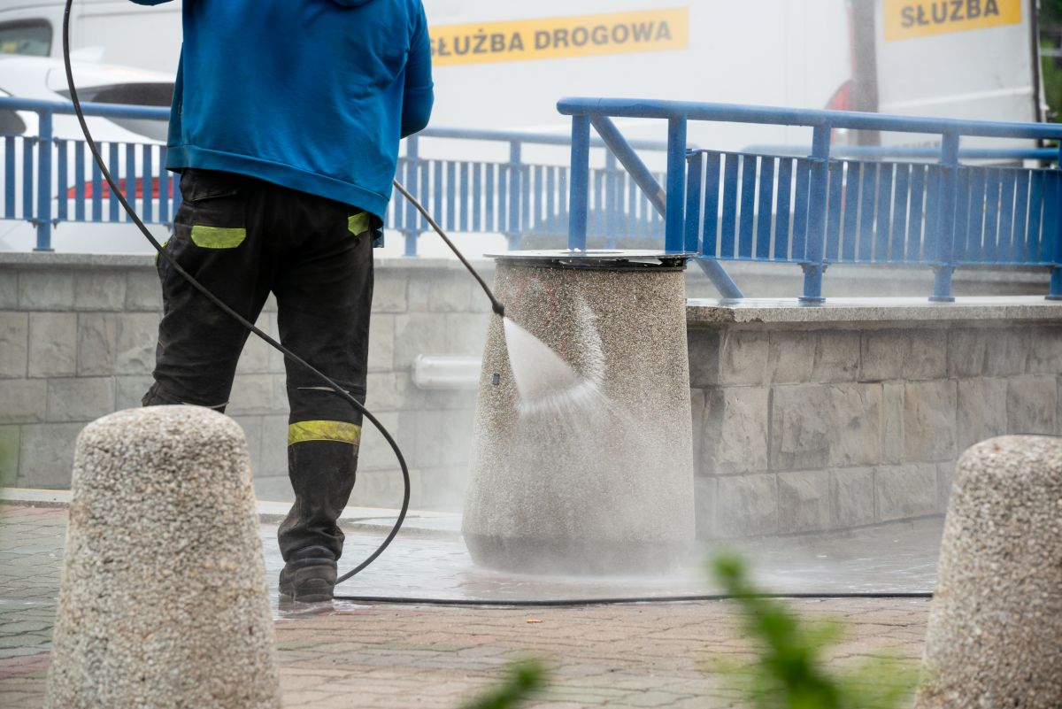 Czyszczenie kosza z pseudograffiti. W tle zejście do metra