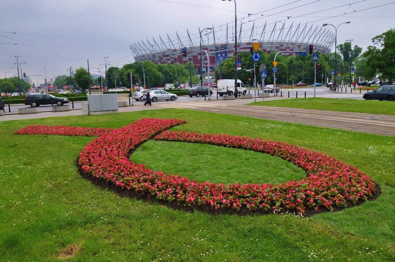 Kwietnik w kształcie symbolu różowej wstążki, w tle Stadion Narodowy