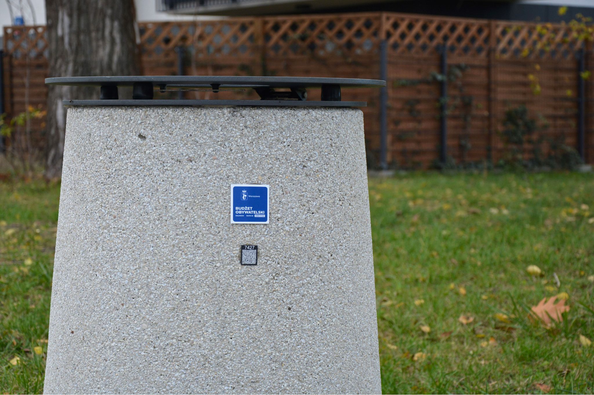 Uliczny kosz na śmieci z pokrywą, na koszu oznaczenie budżetu obywatelskiego