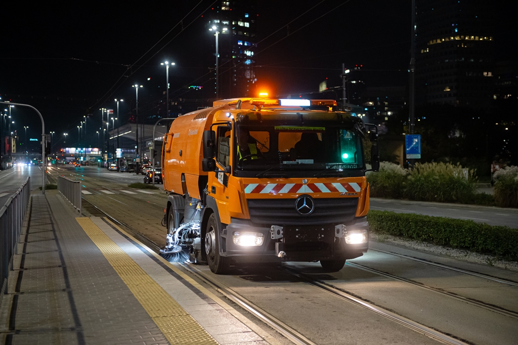 Jest noc, zamiatarka jedzie po torowisku tramwajowym w centrum Warszawy