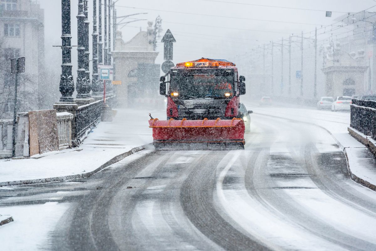 Pługoposypywarka pracuje na jezdni w takcie opadów śniegu