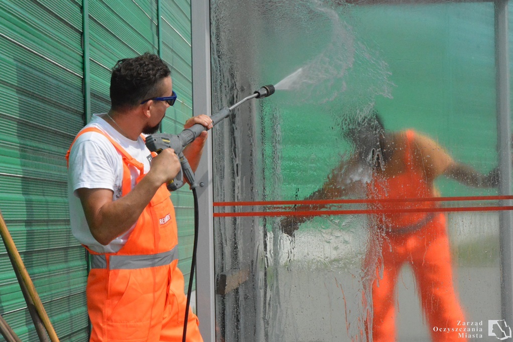 Pracownicy służb oczyszczania miasta myją wiaty wodą pod ciśnieniem