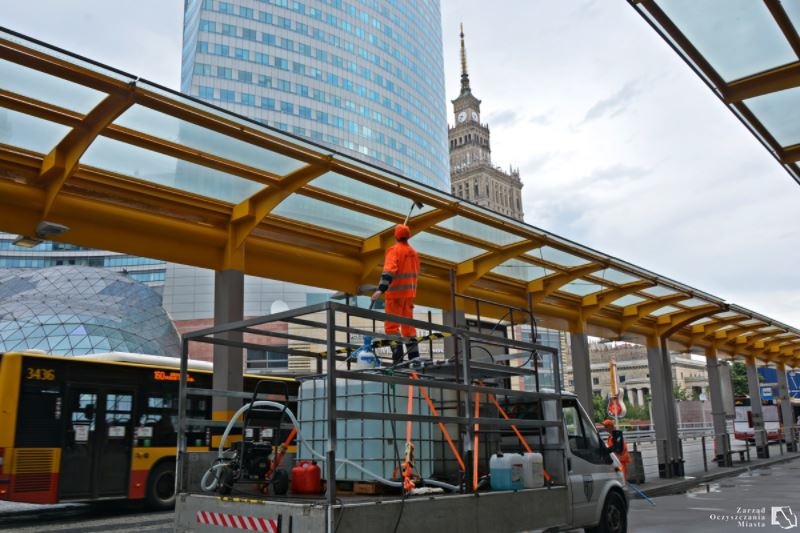 Sprzątacz stoi na rusztowaniu, szczotką na wysięgniku czyści zadaszenie pętli autobusowej przy Dworcu Centralnym