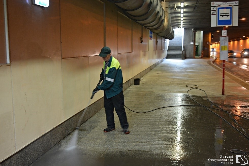Pracownik myje przejście podziemne wodą pod ciśnieniem  
