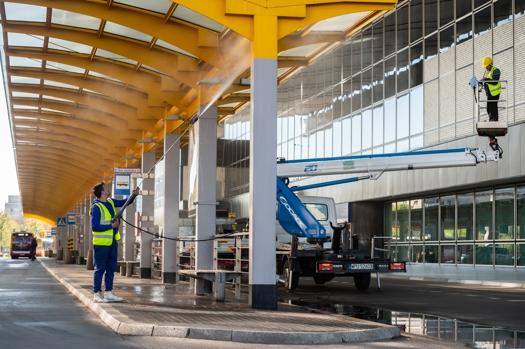 Ekipa porządkowa czyści wodą pod ciśnieniem pętle autobusową. Do sprzątania używają myjek ciśnieniowych i podnośnika