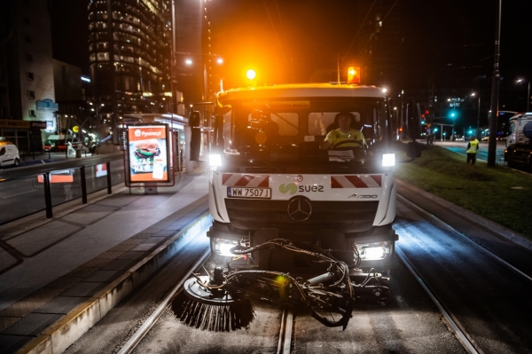 Zamiatarka czyści torowisko tramwajowe nocą